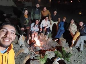 eine Gruppe von Menschen, die um ein Lagerfeuer sitzen in der Unterkunft Viajero Calafate Hostel in El Calafate