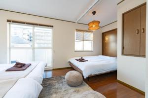 een slaapkamer met 2 bedden en een bank bij Vivere in Tokyo