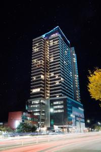 un palazzo alto con luci accese di notte di Hotel The Blue Terra a Sokcho