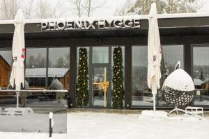 スキュネイザにあるPhoenix Medical Resortの雪中のクリスマスツリーを持つ店頭