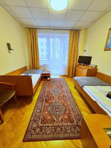 a room with two beds and a rug at 20 Wojskowy Szpital Uzdrowiskowo-Rehabilitacyjny w Krynicy -Zdroju in Krynica Zdrój