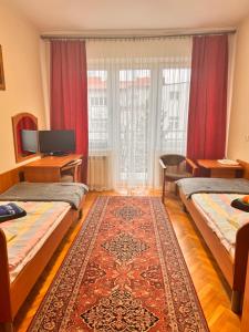 a hotel room with two beds and a rug at 20 Wojskowy Szpital Uzdrowiskowo-Rehabilitacyjny w Krynicy -Zdroju in Krynica Zdrój