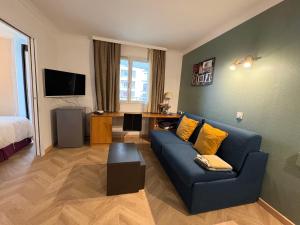 库尔布瓦Appartement 2P avec Terrasse Paris La Défense -Dans Aparthotel的客厅配有蓝色的沙发和床。