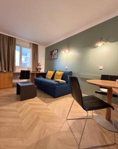 库尔布瓦Appartement 2P avec Terrasse Paris La Défense -Dans Aparthotel的客厅配有蓝色的沙发和桌子