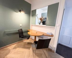 库尔布瓦Appartement 2P avec Terrasse Paris La Défense -Dans Aparthotel的一间带桌子和两把椅子的用餐室