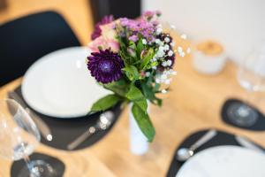 um vaso de flores sobre uma mesa com copos em Hozo1-Exklusiv Apartment der Roze Living em Koblenz