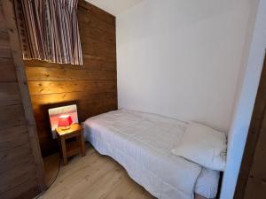 ein kleines Schlafzimmer mit einem Bett und einem Tisch mit einer Lampe in der Unterkunft Appartement triplex avec piscine, parking, animaux acceptés - FR-1-624-169 in Samoëns