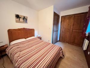 ein Schlafzimmer mit einem großen Bett und einer Holztür in der Unterkunft Appartement triplex avec piscine, parking, animaux acceptés - FR-1-624-169 in Samoëns