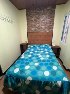 una camera con un letto e un piumone blu e bianco di C&M Exclusive Private Rooms a Quetzaltenango