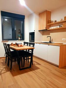 uma cozinha com mesa e cadeiras num quarto em Apartment Holiday Ravna Planina em Gornje Pale