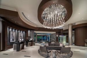 una hall con lampadario pendente, divano e sedie di Renaissance Boston Patriot Place Hotel a Foxborough