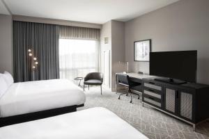 una camera d'albergo con letto e scrivania con TV di Renaissance Boston Patriot Place Hotel a Foxborough