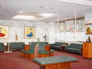 a waiting area with green chairs and a waiting room at Albert Hotel in Akita