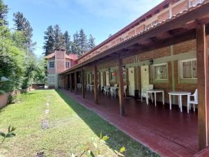 un patio al aire libre con mesas y sillas en un edificio en La Palapa ApartHotel, en Villa General Belgrano