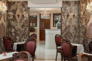 un restaurant avec des tables et des chaises et un lustre dans l'établissement Hotel Montecarlo, à Venise