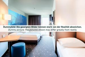 een hotelkamer met 2 bedden en een bureau bij B&B Hotel Bochum Hbf-Süd in Bochum