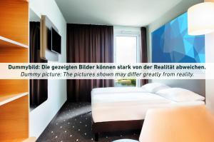 een hotelkamer met een wit bed en een raam bij B&B Hotel Bochum Hbf-Süd in Bochum