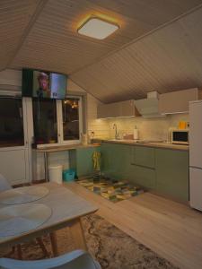 a kitchen with a table and a tv on the ceiling at Три-О Апартаменти з балконом, без сусідів за стінкою, для 2-4 осіб in Slavske