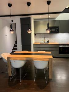 una cocina con una mesa de madera y algunas luces en Appartement LesTiercelins, en Nancy