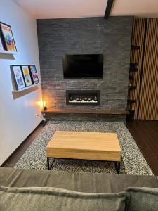 sala de estar con chimenea y TV en una pared de ladrillo en Appartement LesTiercelins, en Nancy