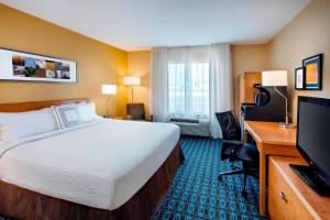 een hotelkamer met een bed en een flatscreen-tv bij Fairfield Inn & Suites Merrillville in Merrillville