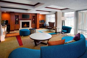 een woonkamer met blauwe meubels en een open haard bij Fairfield Inn & Suites Merrillville in Merrillville