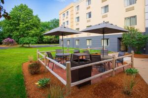 ミドルバラにあるFairfield by Marriott Inn & Suites Raynham Middleborough/Plymouthの建物の前にパティオ(テーブル、パラソル付)