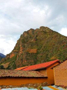 duża góra z budynkiem przed nią w obiekcie Punto Sagrado w mieście Ollantaytambo