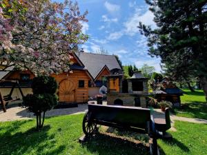 una panchina nell'erba di fronte a una casa di Willa Florynka a Biały Dunajec