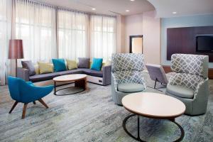 een woonkamer met een bank, stoelen en tafels bij Courtyard by Marriott Roanoke Airport in Roanoke