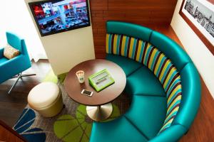 Courtyard by Marriott Aberdeen Airport في دايس: غرفة بها كرسي أزرق وطاولة مع لاب توب