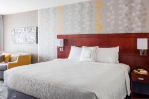 A bed or beds in a room at Courtyard by Marriott Kalamazoo Portage