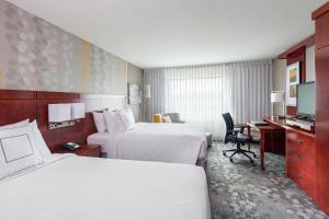 A bed or beds in a room at Courtyard by Marriott Kalamazoo Portage