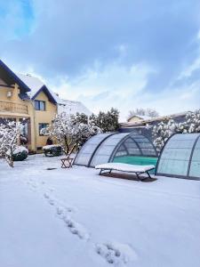 un cortile coperto di neve con cupole e panchine di Orchard Villa a Braşov