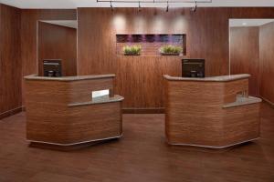 a lobby with wooden walls and two reception desks at Courtyard by Marriott Houma in Houma