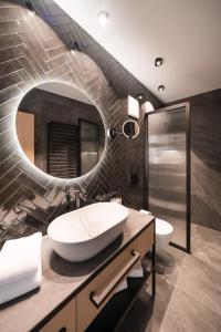 a bathroom with a large white sink and a mirror at Schwarzer Adler - Concept Living in Vipiteno