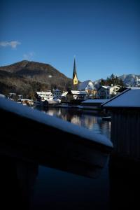 un bateau est amarré dans un port avec une ville dans l'établissement Althoff Seehotel Überfahrt, à Rottach-Egern