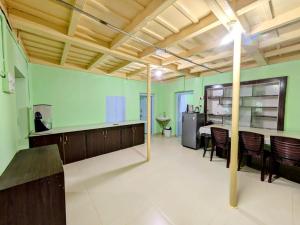 a large room with green walls and wooden ceilings at Thanmaya Homestay in Chikmagalūr