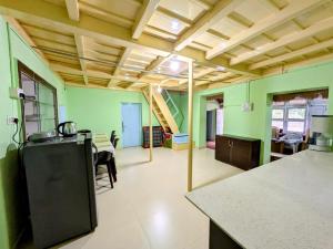 an office with green walls and a kitchen with a table at Thanmaya Homestay in Chikmagalūr