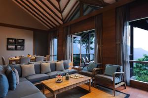 a living room with a couch and a table at Taj Chia Kutir Resort & Spa Darjeeling in Darjeeling