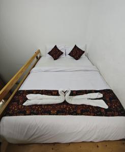 - un lit avec 2 serviettes blanches dans l'établissement Jogja Amor Hotel, à Demangan