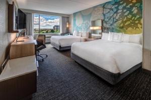 ein Hotelzimmer mit 2 Betten und einem Schreibtisch in der Unterkunft Courtyard by Marriott Dulles Airport Herndon in Herndon