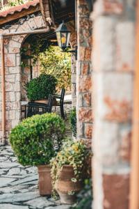 a stone walkway with two chairs and potted plants at Aphrodite's Inn Kalavrita in Kalavrita