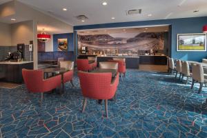 a hotel lobby with red chairs and a bar at Fairfield Inn & Suites by Marriott Altoona in Altoona