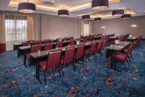 a conference room with tables and red chairs at Fairfield Inn & Suites by Marriott Altoona in Altoona