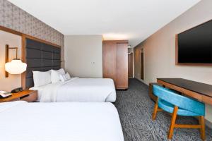 um quarto de hotel com duas camas e uma secretária e uma televisão em Fairfield Inn & Suites by Marriott Kalamazoo em Kalamazoo