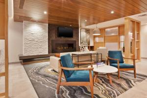 uma sala de estar com uma mesa e cadeiras e uma lareira em Fairfield Inn & Suites by Marriott Kalamazoo em Kalamazoo