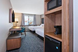 um quarto de hotel com uma cama e uma televisão em Fairfield Inn & Suites by Marriott Kalamazoo em Kalamazoo