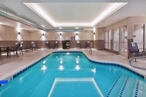 una piscina in una camera d'albergo con sedie e tavoli di Fairfield Inn & Suites by Marriott Kalamazoo a Kalamazoo