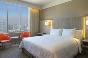 een hotelkamer met een bed en een groot raam bij Courtyard by Marriott Santiago Las Condes in Santiago